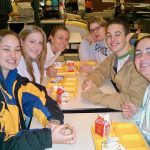 School students eating lunch with fruit in a cafeteria