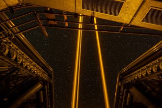 A telescope silhouetted against a star-filled night sky at an observatory