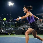 Tennis player in action on a hard court at the Wuhan Open under stadium lights